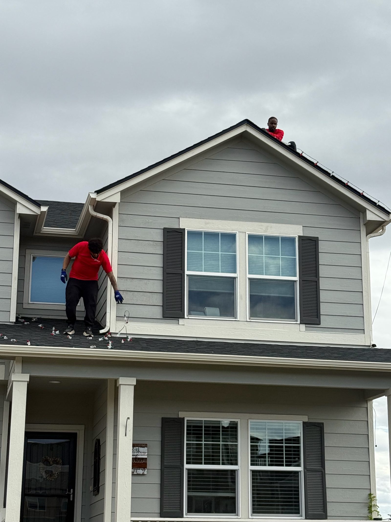 Professional Christmas light installation crew on roof installing LED lights on a Front Range home Professional Christmas light installation crew on roof installing LED lights on a Front Range home