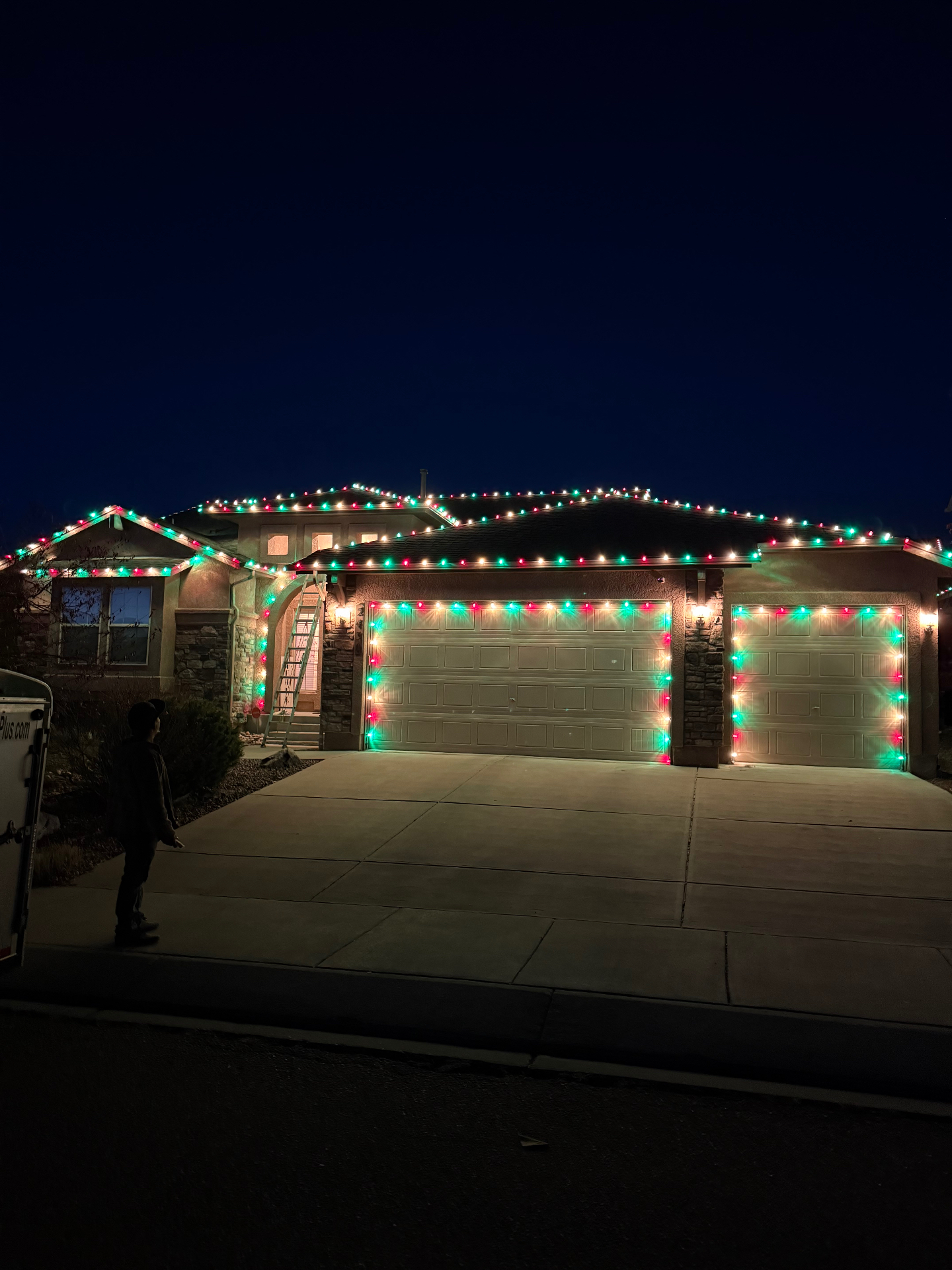 Classic red and green Red and green residential Christmas light installation across a home's roofline and garage, Front Range portfolio