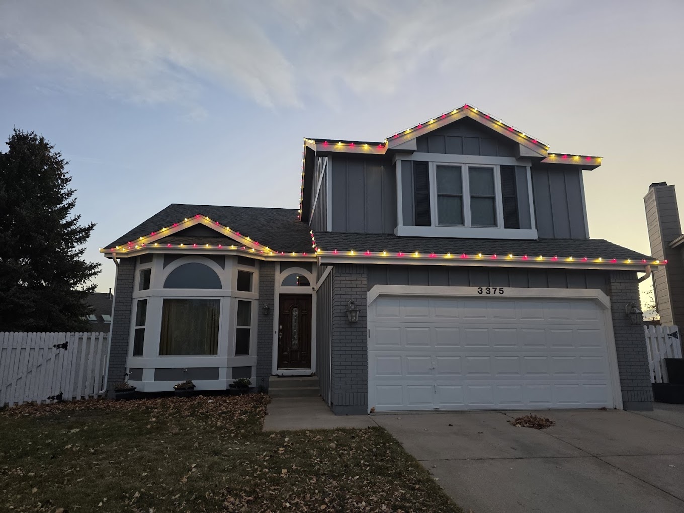 Two-story multicolor lights Two-story home decorated with multicolor roofline Christmas lights for the holiday season