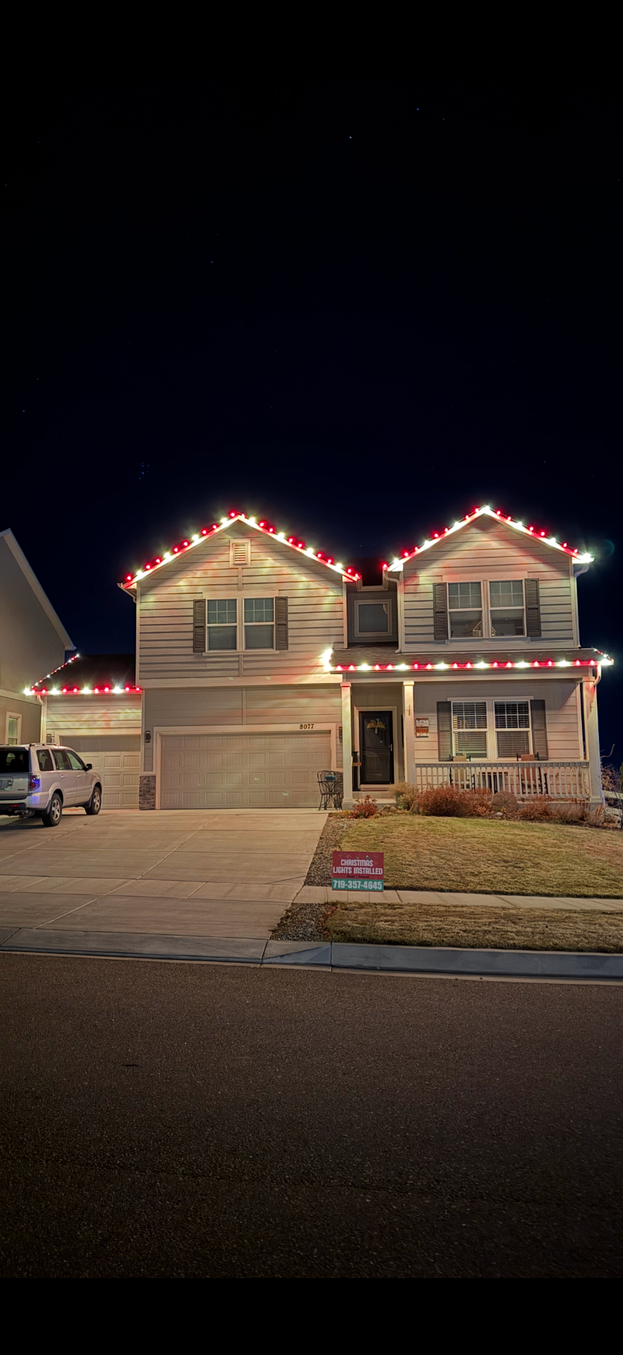 Red and white roofline Red and white Christmas light installation on a two-story home's roofline and garage